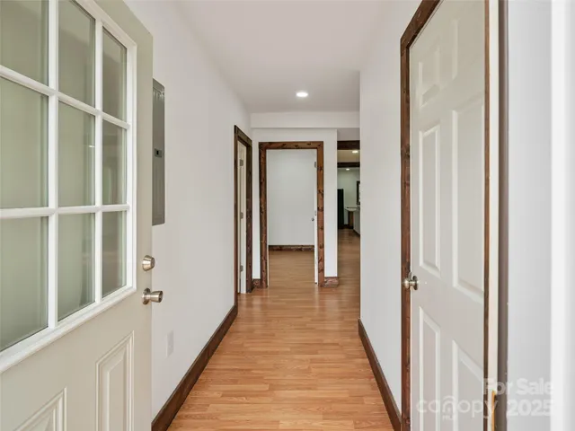 a view of a hallway with wooden floor and entryway