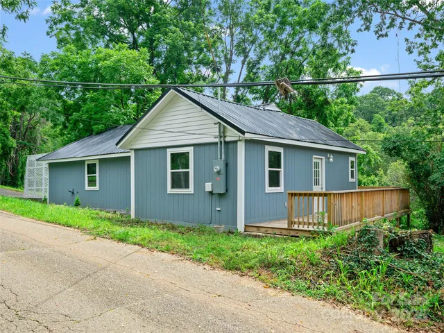 a view of a house with a yard and large tree