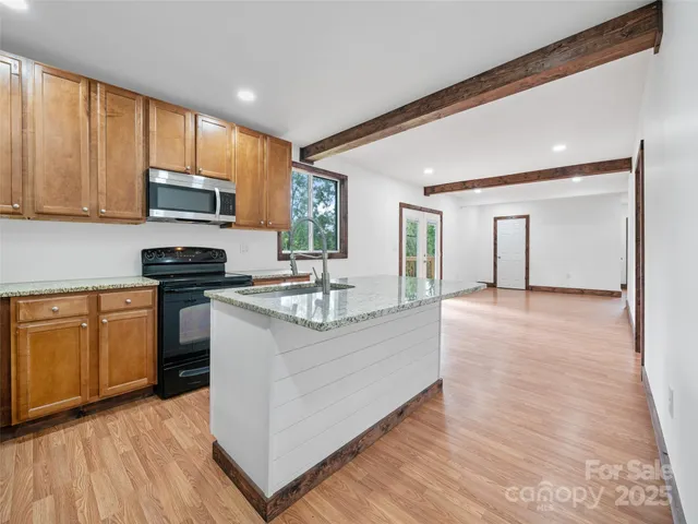 a kitchen with stainless steel appliances granite countertop a stove a sink and a refrigerator