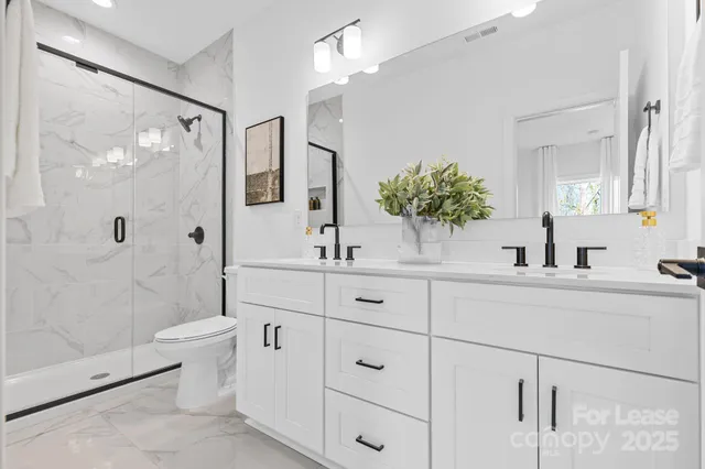 a bathroom with a double vanity sink toilet and shower