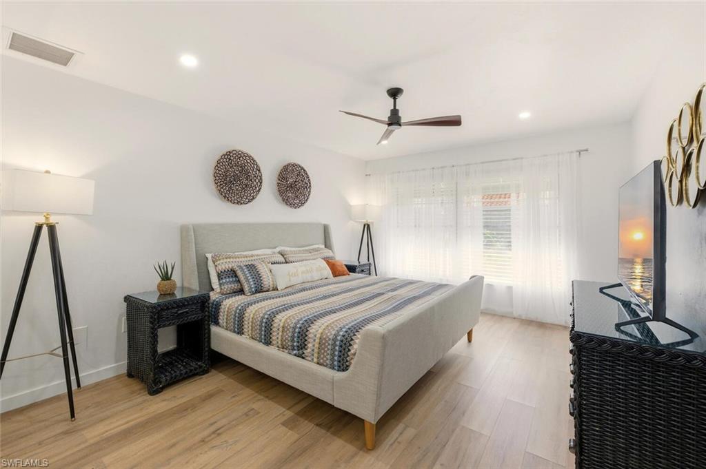 772 Reef Point Circle Naples, FL 34108 - Photo 12 of 46 a bedroom with a large bed and a chandelier