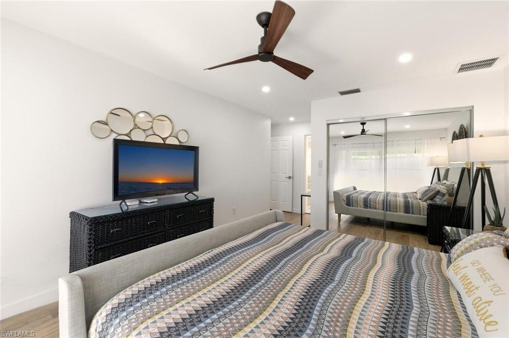 772 Reef Point Circle Naples, FL 34108 - Photo 13 of 46 a bedroom with furniture and a flat screen tv