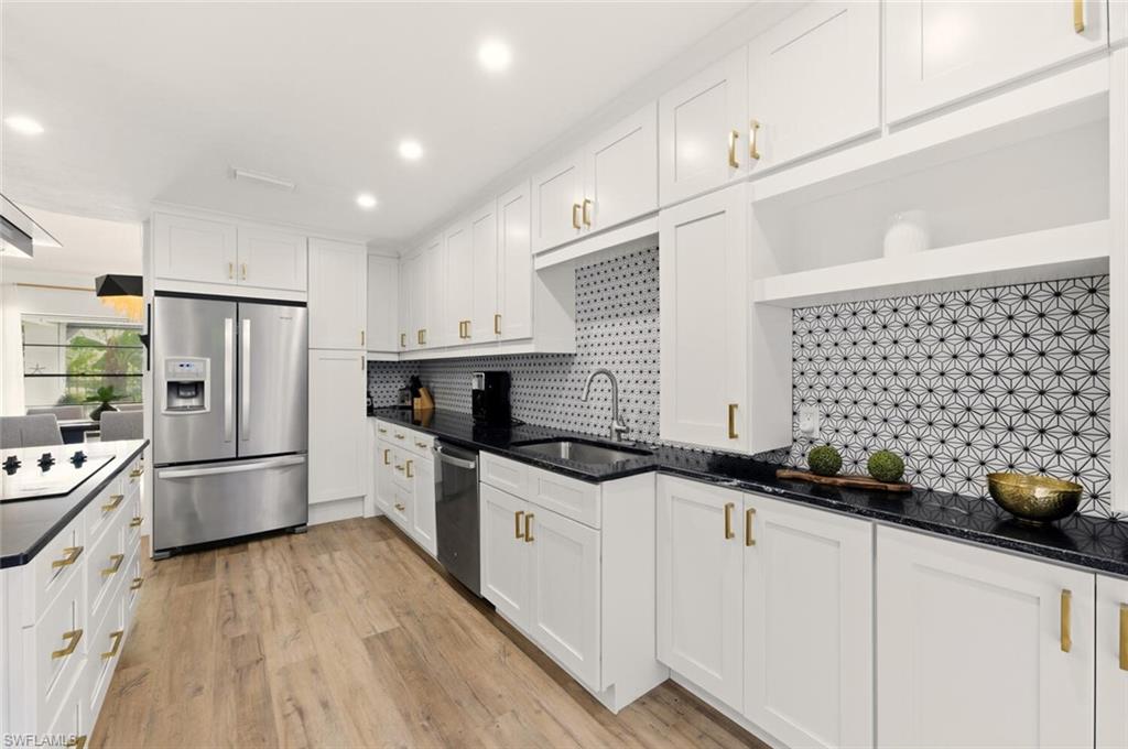 772 Reef Point Circle Naples, FL 34108 - Photo 2 of 46 a kitchen with granite countertop a sink a stove a refrigerator and cabinets