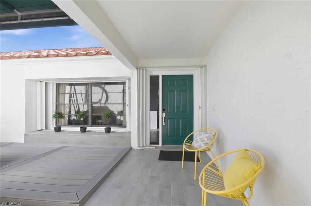 772 Reef Point Circle Naples, FL 34108 - Photo 30 of 46 a living room with furniture a flat screen tv and floor to ceiling window