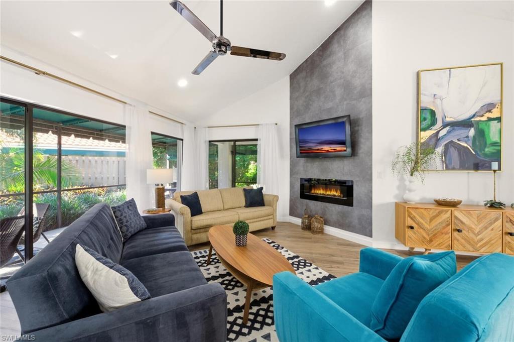 772 Reef Point Circle Naples, FL 34108 - Photo 8 of 46 a living room with furniture and a fireplace