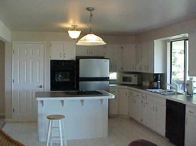 14208 Fisk Road Yakima, WA 98908 - Photo 4 of 9 a kitchen with kitchen island granite countertop a sink a counter top space cabinets and stainless steel appliances