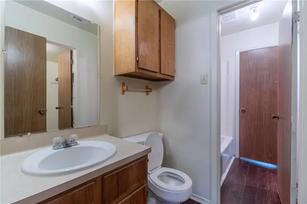 a bathroom with a toilet a sink and mirror