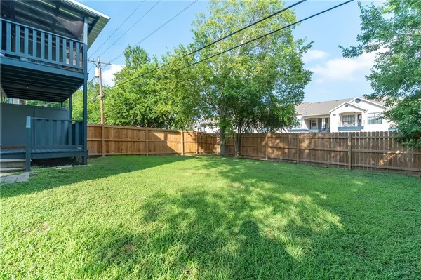 a view of a backyard with plants and wooden fence