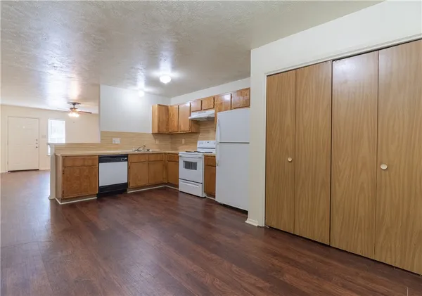 a view of kitchen with wooden floor and electronic appliances