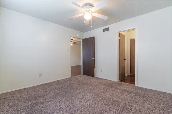 a view of an empty room and a ceiling fan
