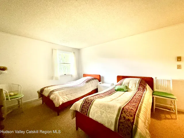 a bedroom with two beds and painting on the wall