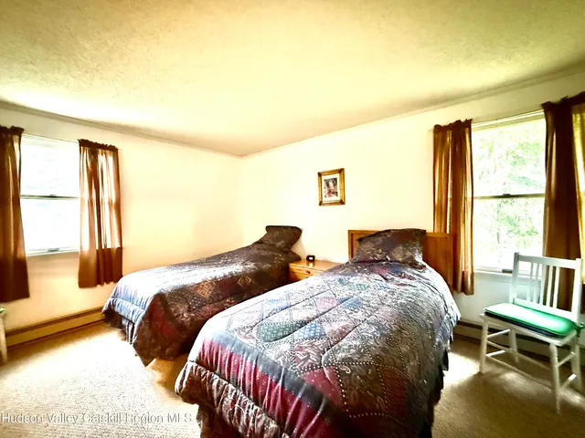 a bedroom with two beds and a large window