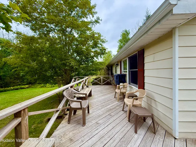 a view of a patio with couches table and chairs with wooden floor and fence