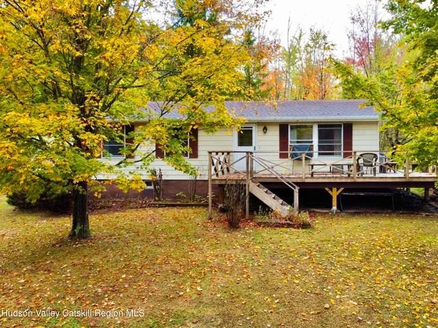 a view of a house with pool and chairs