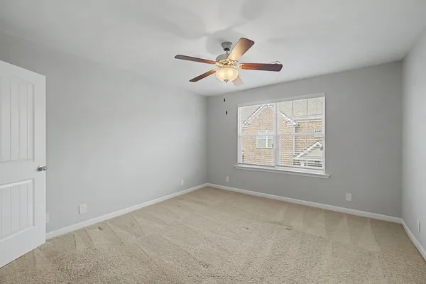 an empty room with windows and fan
