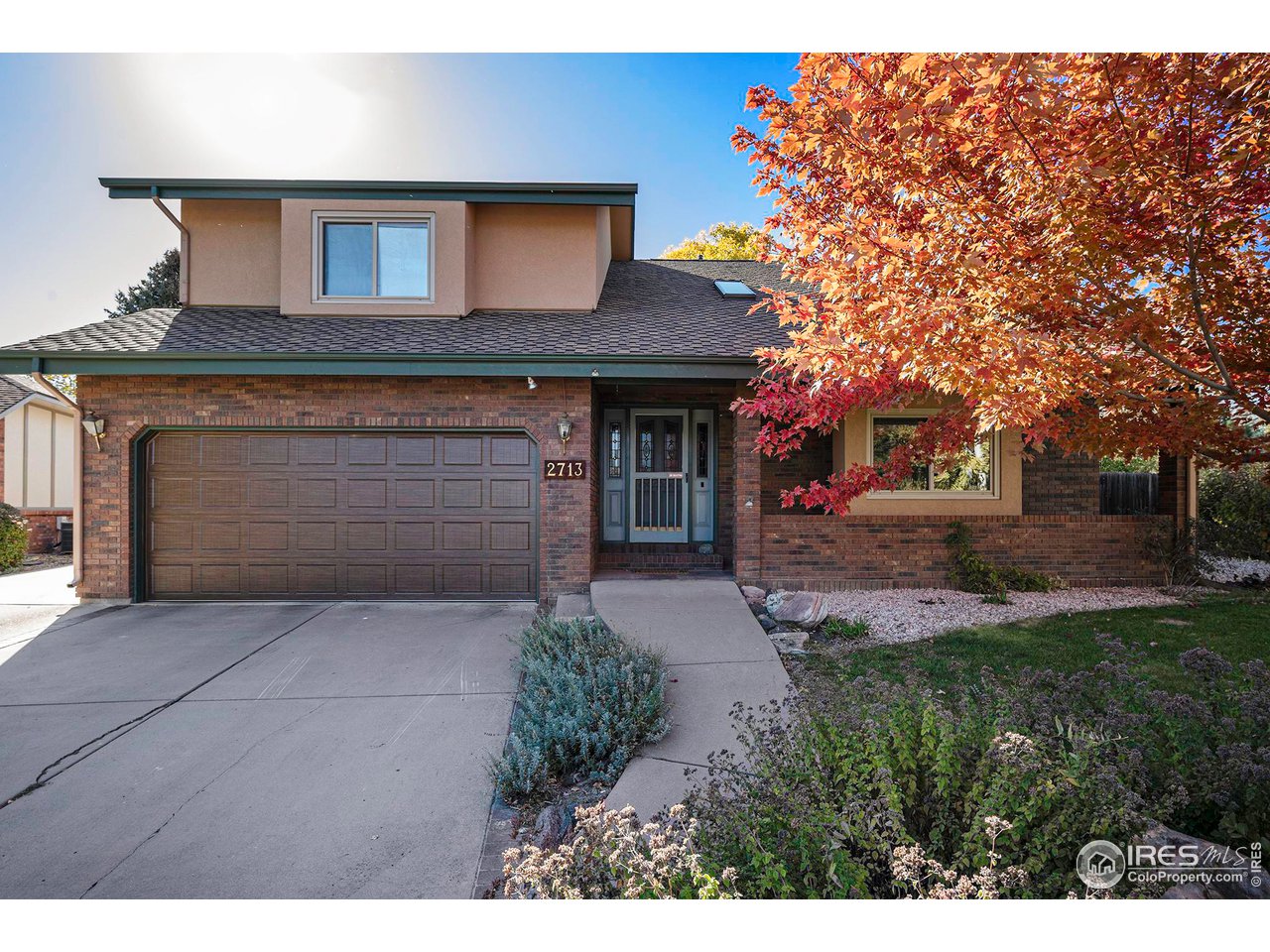 a front view of a house with yard and trees