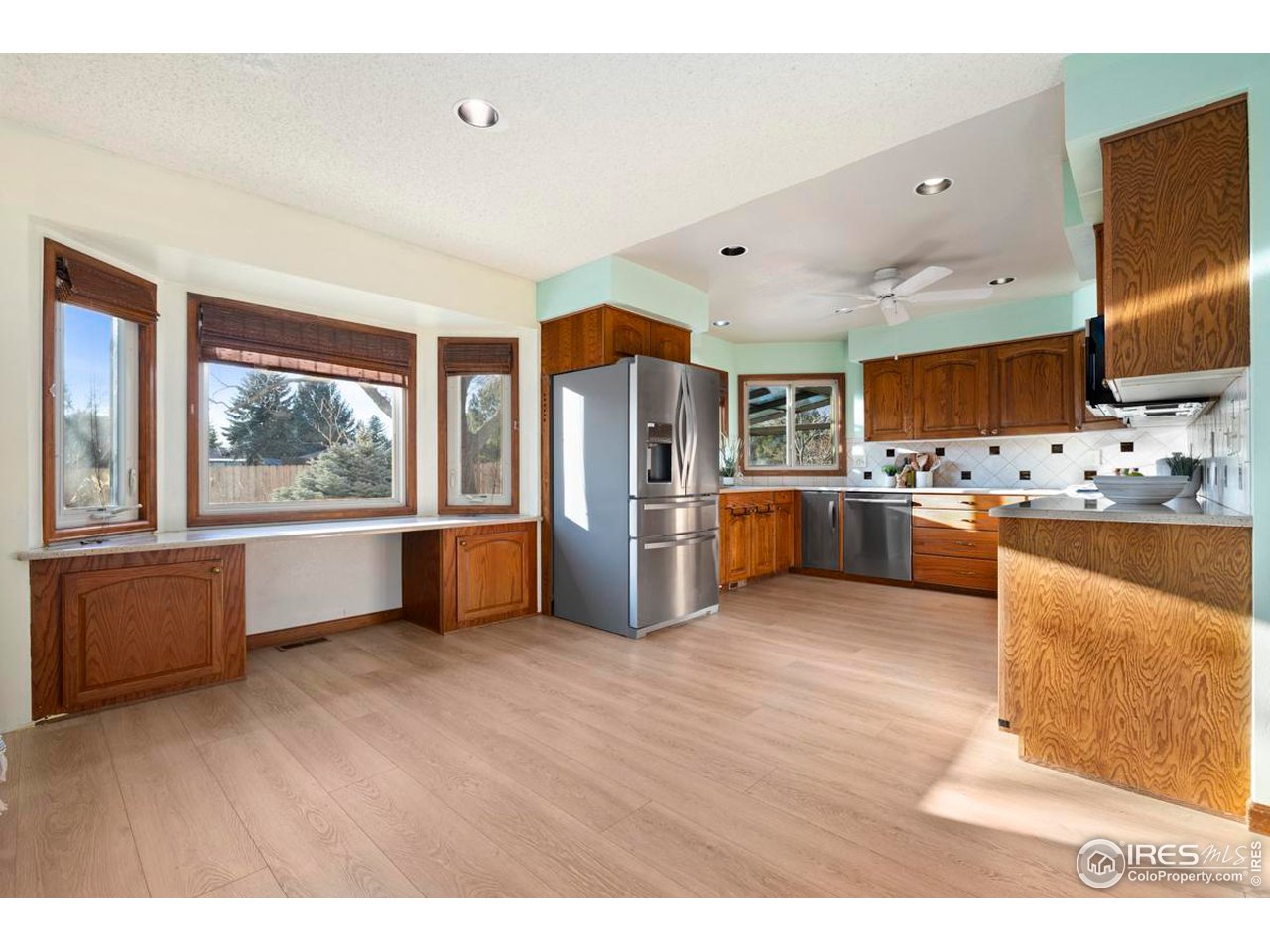 2713 Beech Way Longmont, CO 80503 - Photo 13 of 36 a kitchen with stainless steel appliances wooden floor and large windows