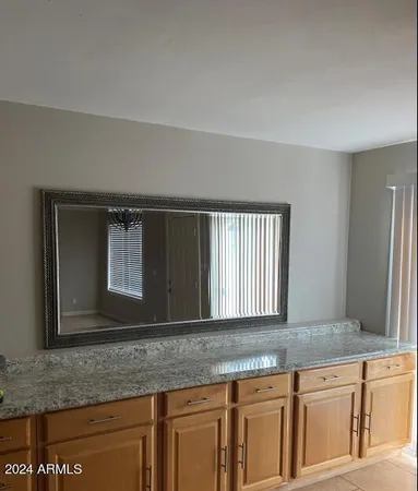 a kitchen with granite countertop a sink and a white cabinets