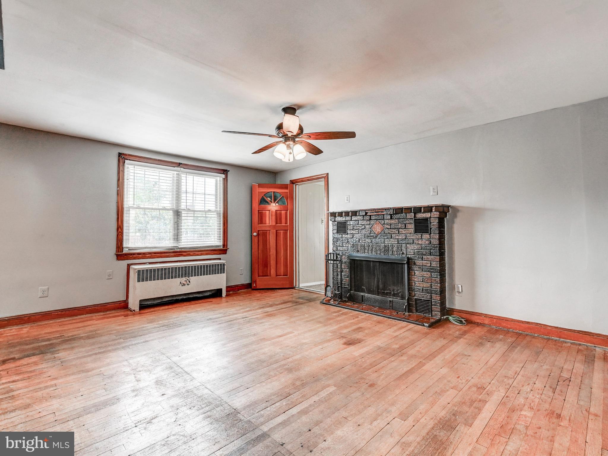 3206 Lynch Road Baltimore, MD 21219 - Photo 8 of 70 a view of an empty room with wooden floor fireplace and a window