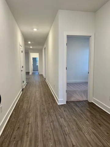 a view of a big room with wooden floor and windows