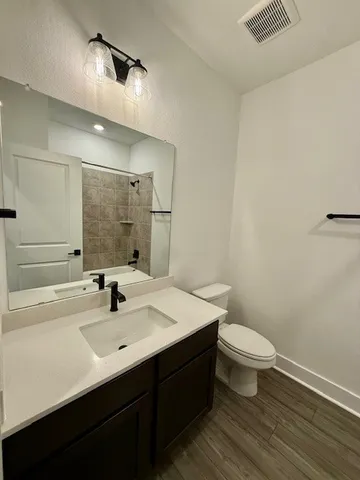 a bathroom with a sink a toilet and mirror