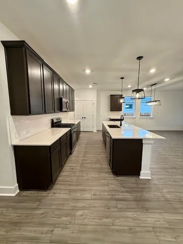 a kitchen with kitchen island granite countertop a stove top oven and cabinets