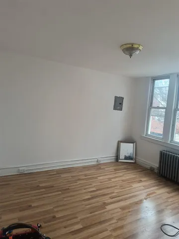 a room with wooden floor and windows