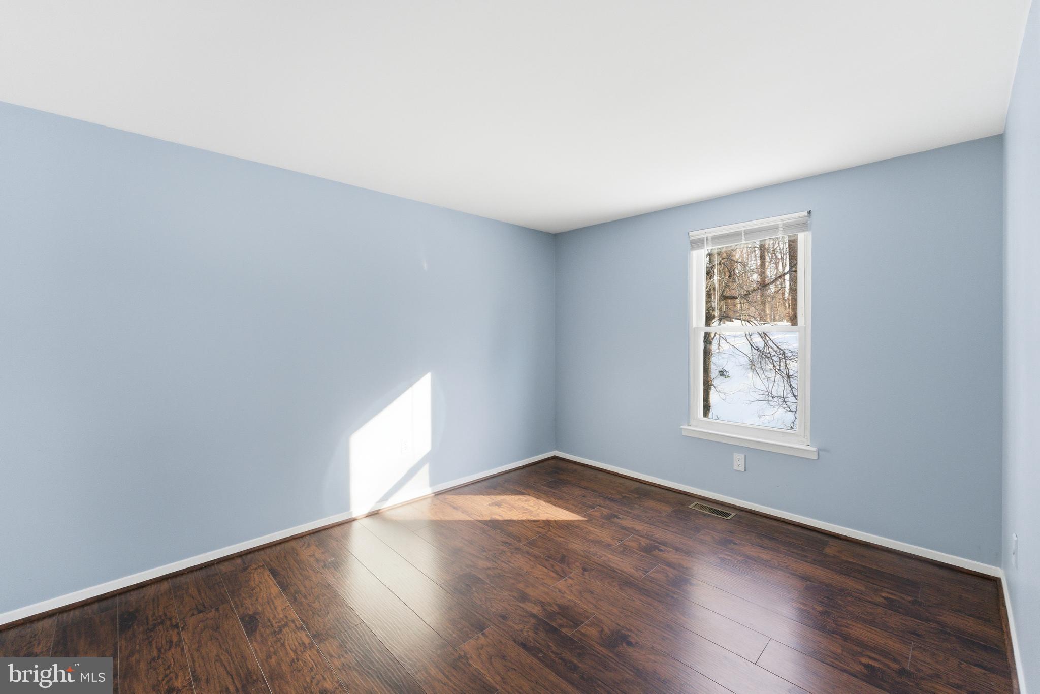 14629 Sandy Ridge Road Silver Spring, MD 20905 - Photo 24 of 47 an empty room with wooden floor and windows