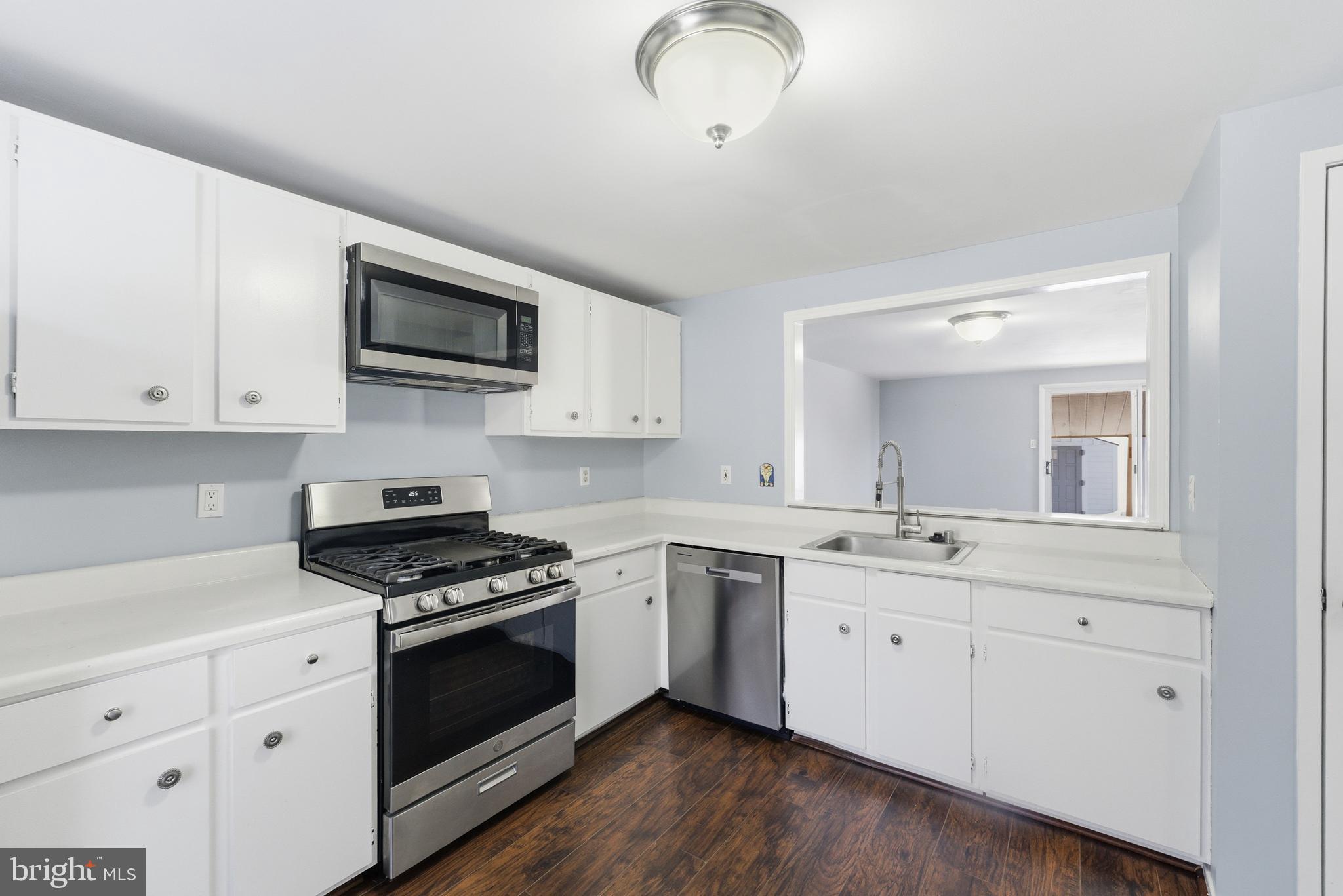 14629 Sandy Ridge Road Silver Spring, MD 20905 - Photo 6 of 47 a kitchen with white cabinets stainless steel appliances and sink