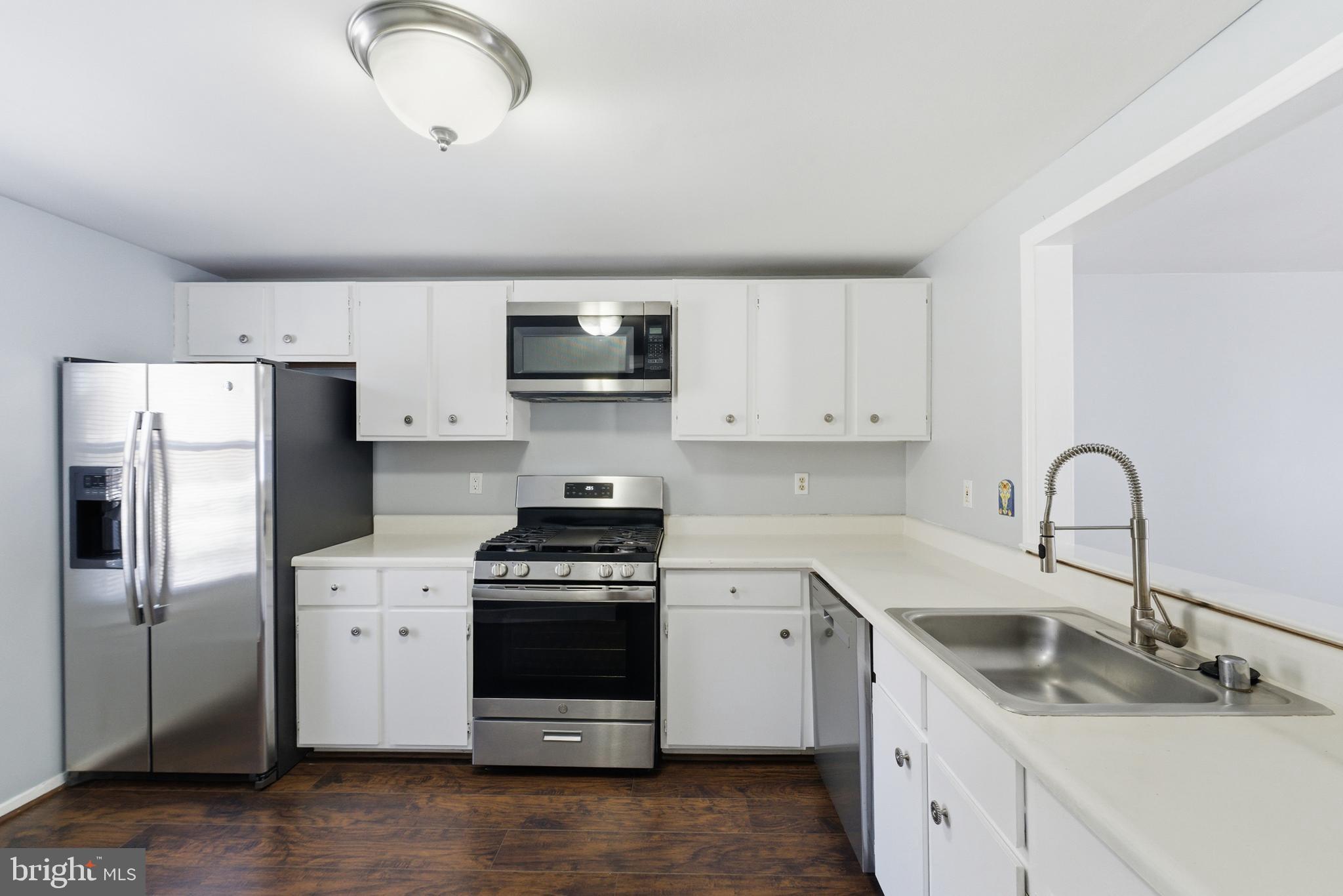 14629 Sandy Ridge Road Silver Spring, MD 20905 - Photo 7 of 47 a kitchen with stainless steel appliances a sink cabinets and a refrigerator