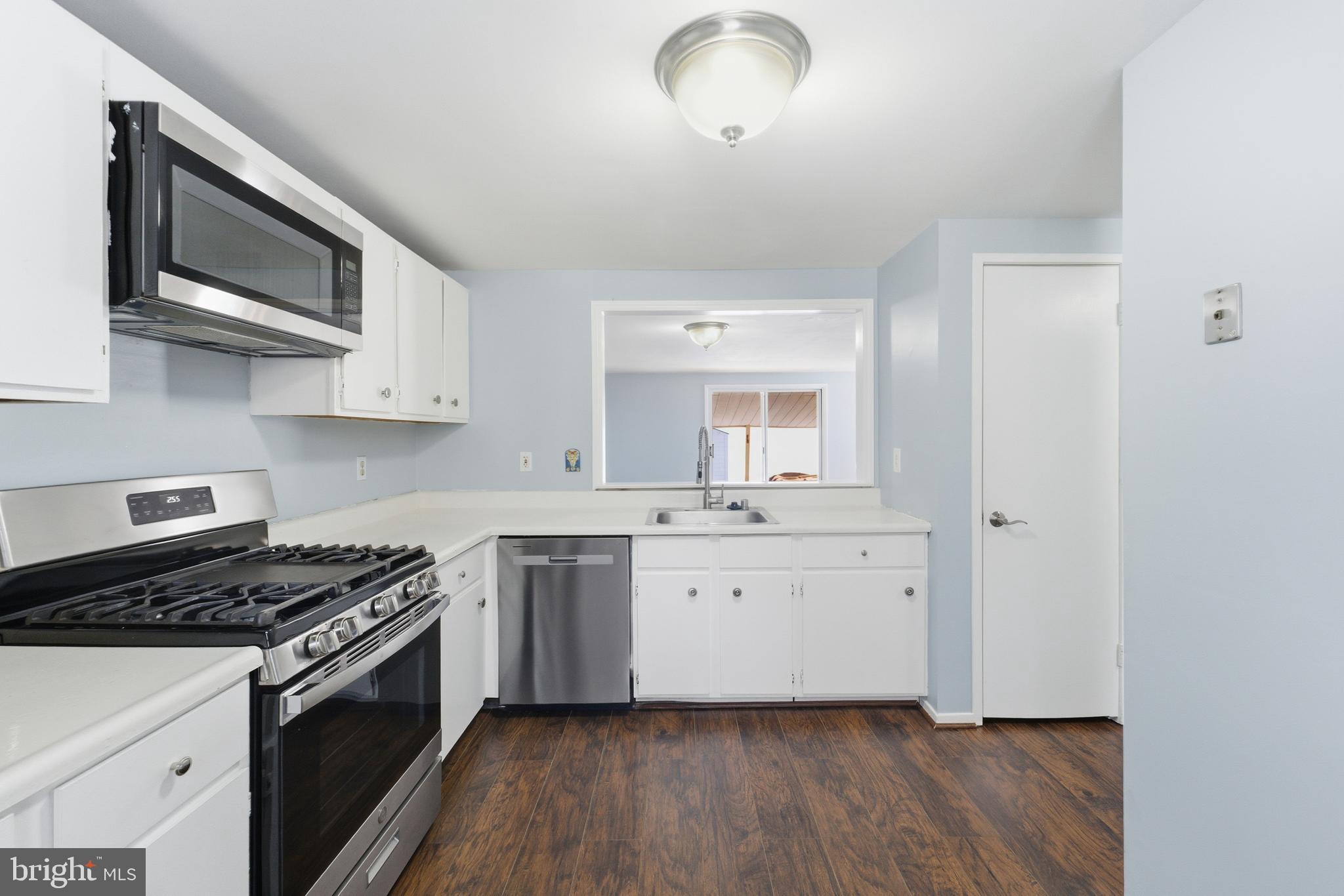 14629 Sandy Ridge Road Silver Spring, MD 20905 - Photo 8 of 47 a kitchen with stainless steel appliances a sink stove and microwave