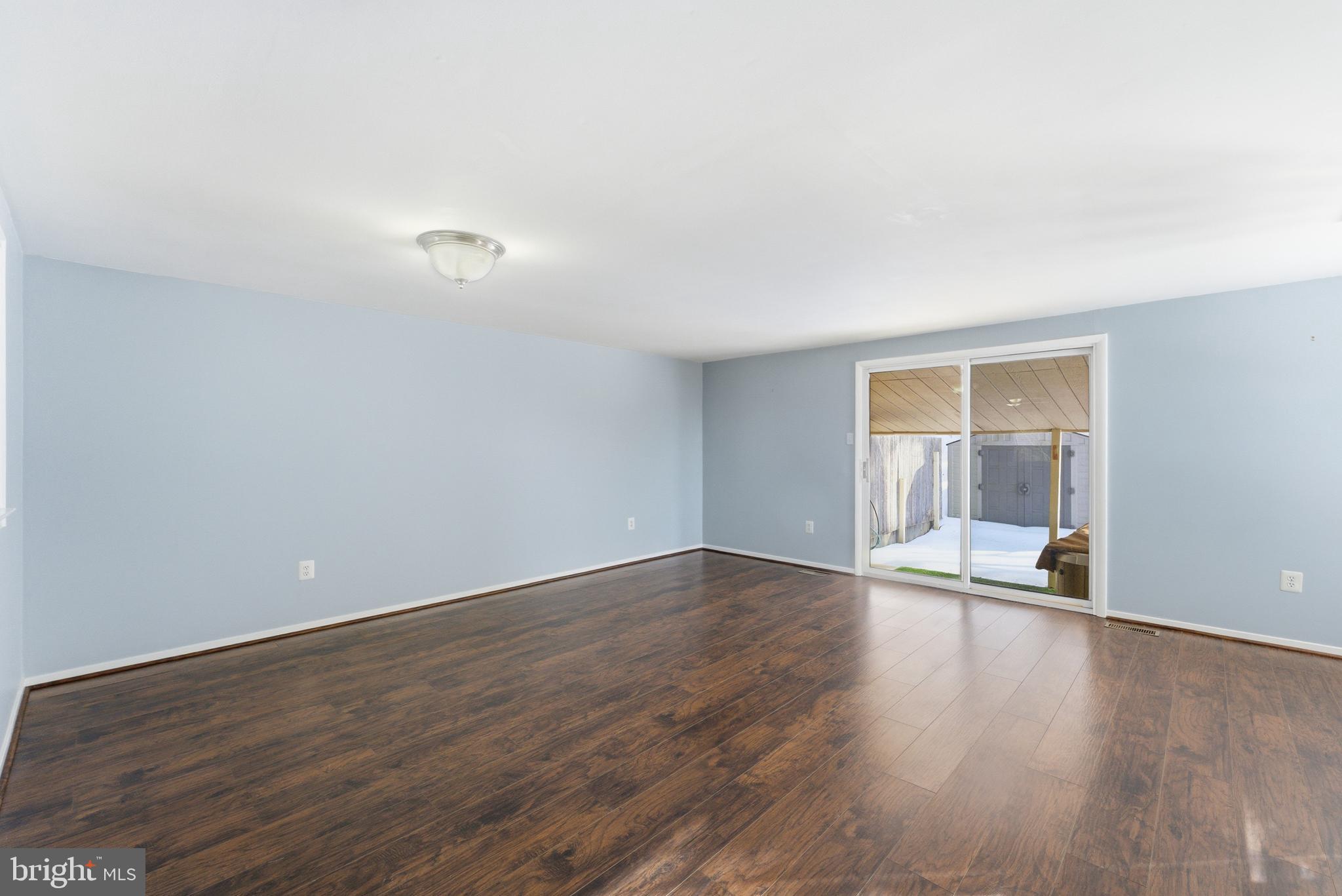 14629 Sandy Ridge Road Silver Spring, MD 20905 - Photo 9 of 47 a view of an empty room with wooden floor and a window