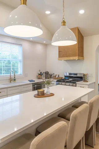 a kitchen with stainless steel appliances granite countertop a sink and a stove