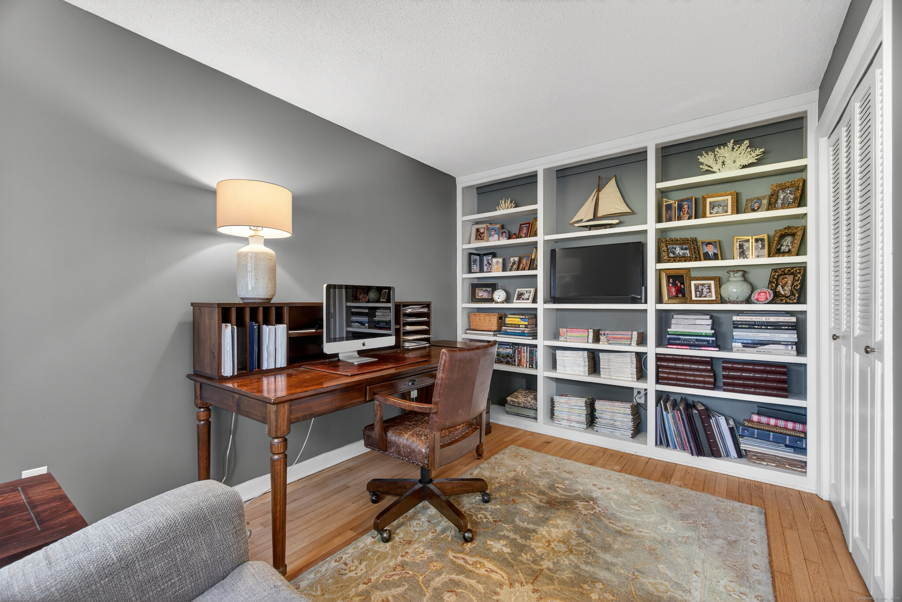 84 Hop Brook Road Simsbury, CT 06070 - Photo 20 of 36 a view of a workspace with furniture and a bookshelf