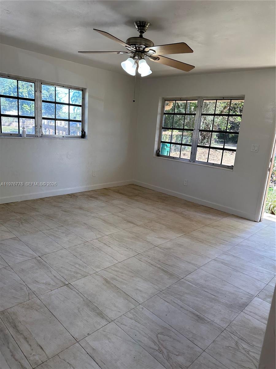 22840 Southwest 155th Avenue, Unit 2 Miami, FL 33170 - Photo 3 of 13 an empty room with windows and ceiling fan