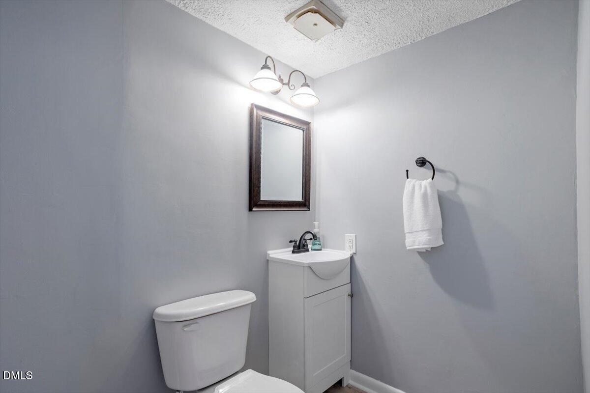 712 Godwin Court Raleigh, NC 27606 - Photo 8 of 27 a bathroom with a toilet sink and mirror