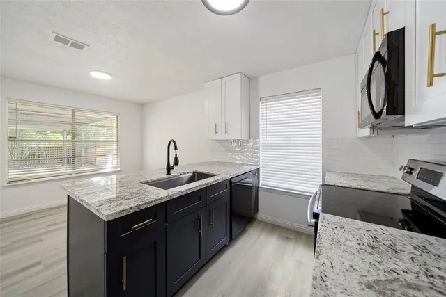a kitchen with a sink stove and cabinets