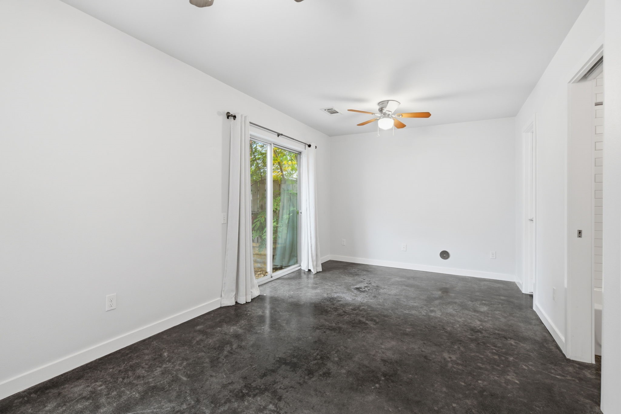 2934 Commerce Street Houston, TX 77003 - Photo 30 of 44 an empty room with a ceiling fan and a window