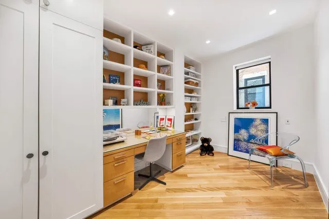 a view of a workspace with furniture and a window