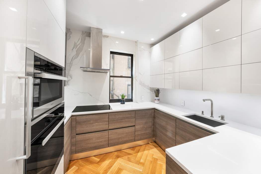 1356 Madison Avenue, Unit 3S Manhattan, NY 10128 - Photo 7 of 16 a kitchen with a sink stainless steel appliances and cabinets