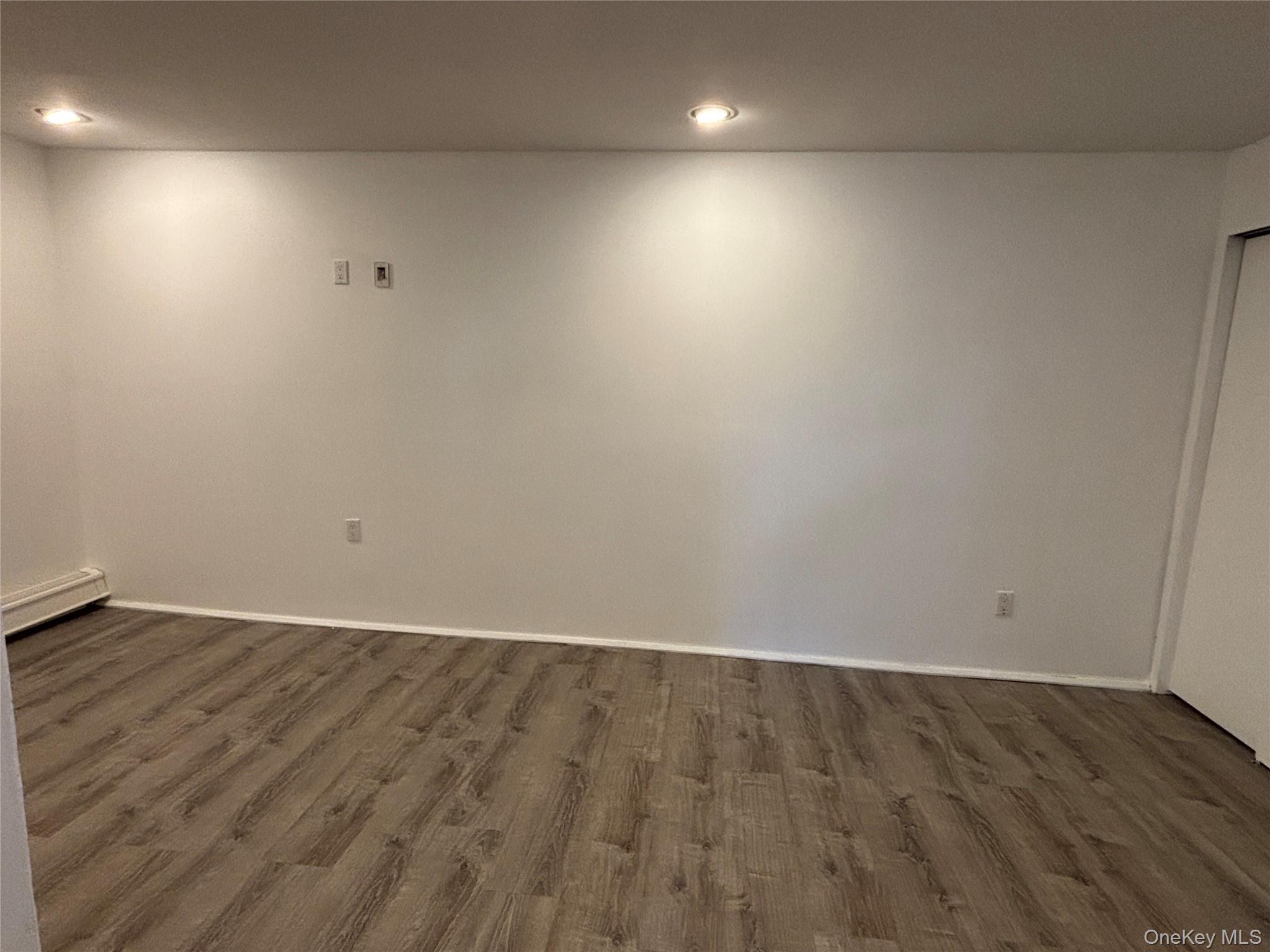 40 Canoe Place Road, Unit 4 Hampton Bays, NY 11946 - Photo 13 of 36 an empty room with wooden floor and windows