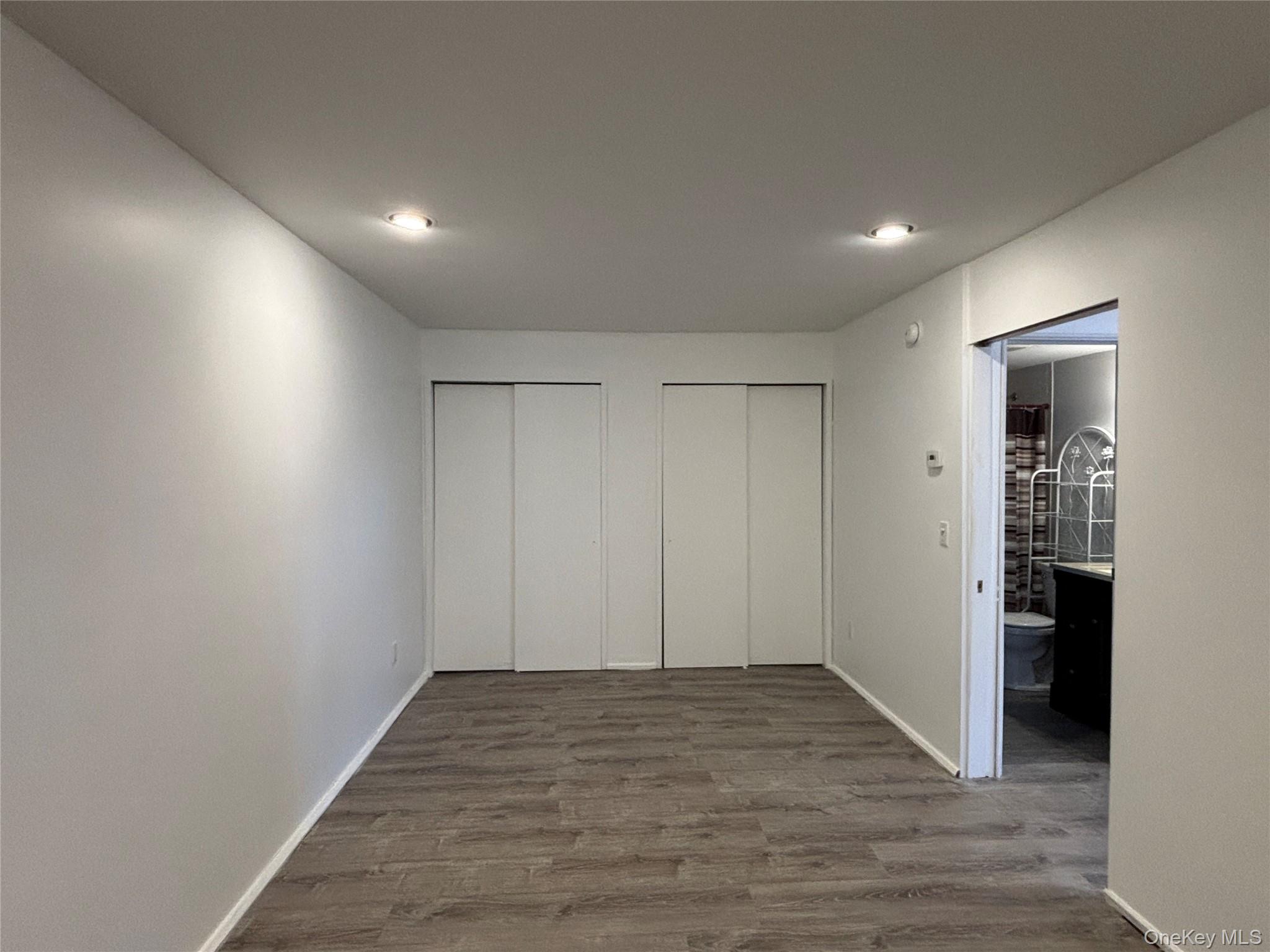 40 Canoe Place Road, Unit 4 Hampton Bays, NY 11946 - Photo 14 of 36 Unfurnished bedroom featuring two closets, dark wood-type flooring, and recessed lighting