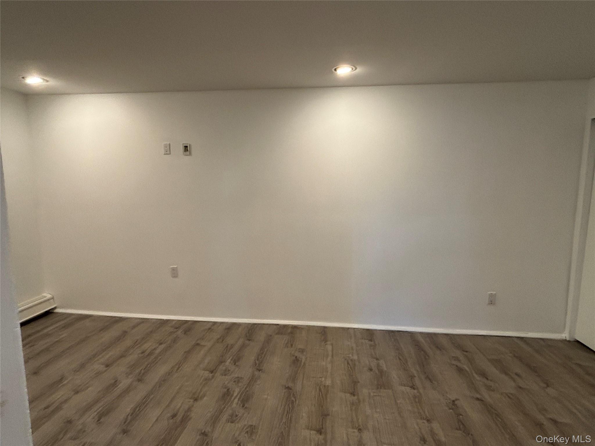 40 Canoe Place Road, Unit 4 Hampton Bays, NY 11946 - Photo 15 of 36 an empty room with wooden floor and windows