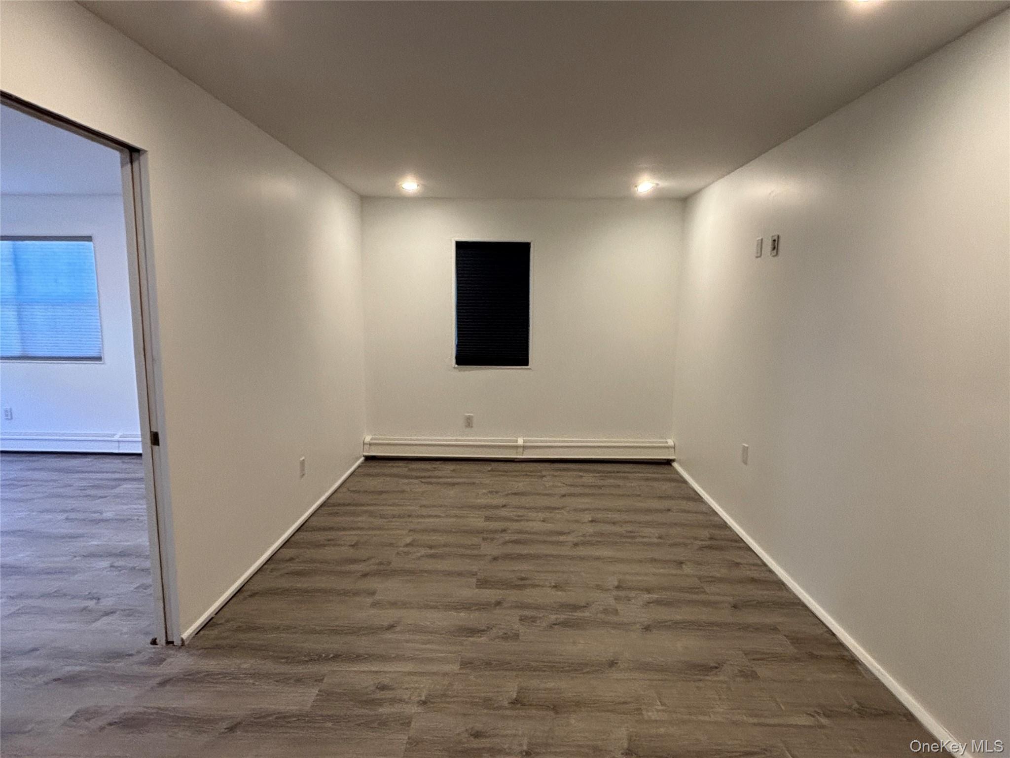 40 Canoe Place Road, Unit 4 Hampton Bays, NY 11946 - Photo 17 of 36 an empty room with wooden floor and windows