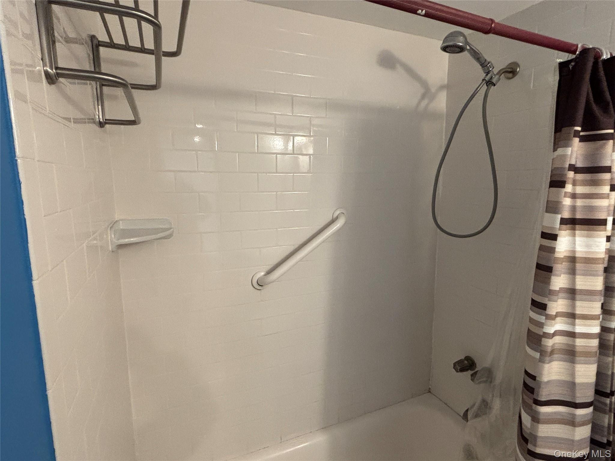 40 Canoe Place Road, Unit 4 Hampton Bays, NY 11946 - Photo 20 of 36 a bathroom with a bath tub with a glass shower door