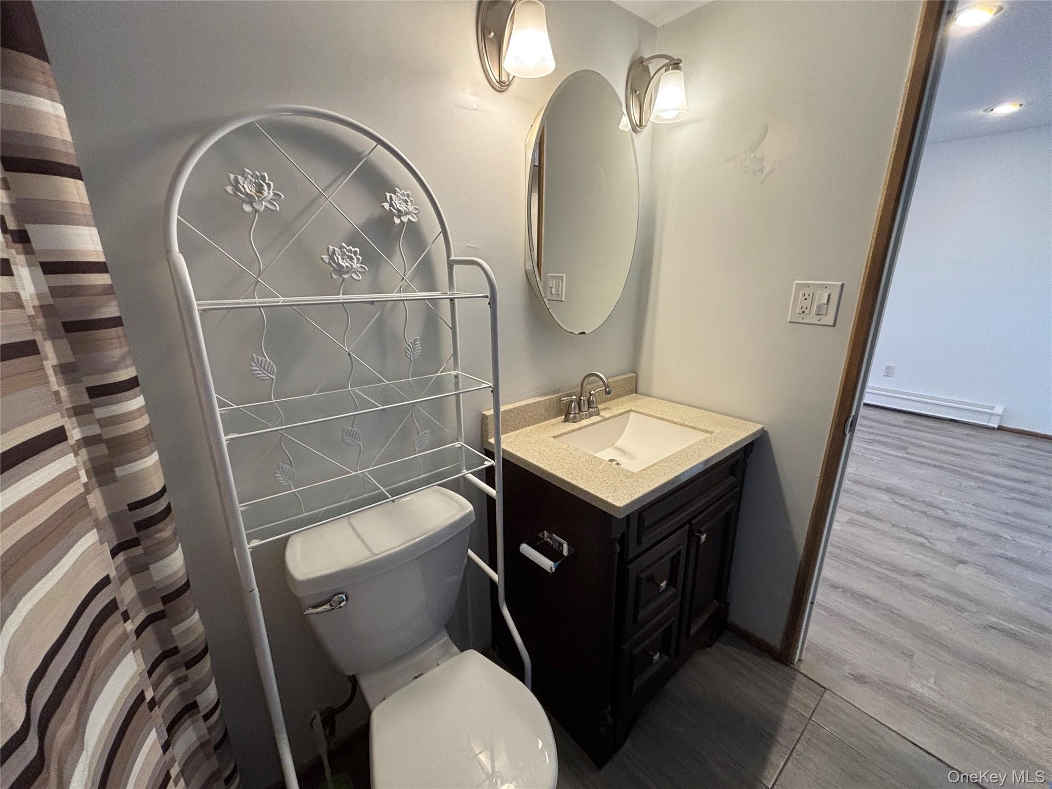 40 Canoe Place Road, Unit 4 Hampton Bays, NY 11946 - Photo 21 of 36 a bathroom with a toilet a sink and mirror