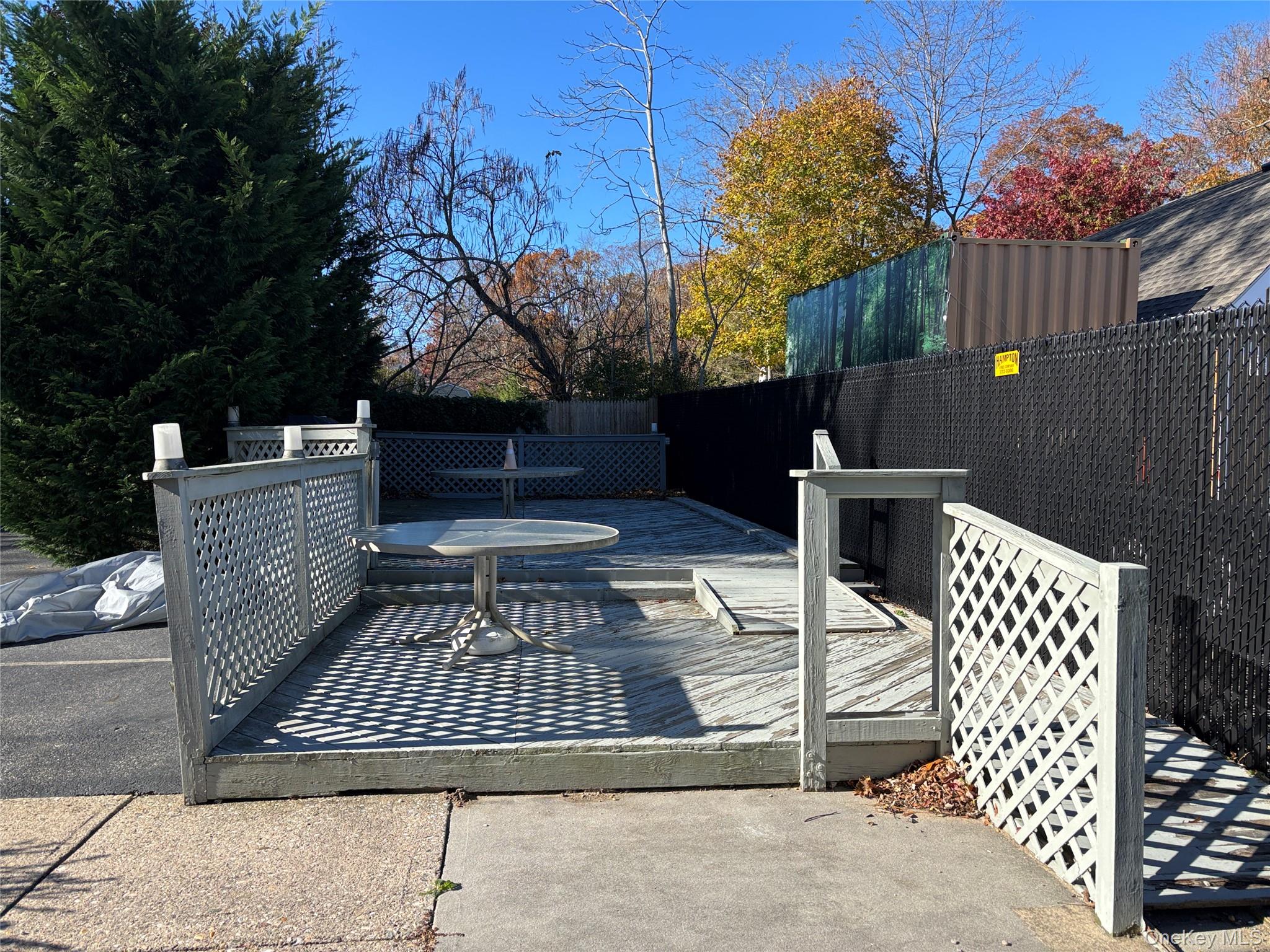 40 Canoe Place Road, Unit 4 Hampton Bays, NY 11946 - Photo 24 of 36 a view of backyard with barbeque grill and wooden fence