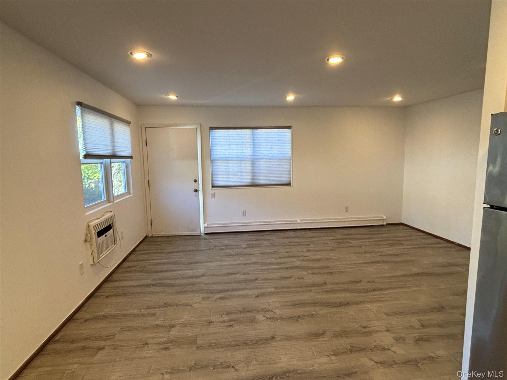 40 Canoe Place Road, Unit 4 Hampton Bays, NY 11946 - Photo 6 of 36 an empty room with wooden floor and windows