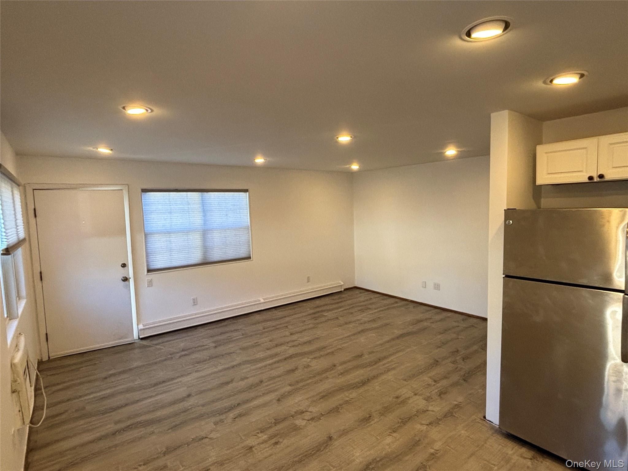 40 Canoe Place Road, Unit 4 Hampton Bays, NY 11946 - Photo 7 of 36 a view of a refrigerator in kitchen and wooden floor