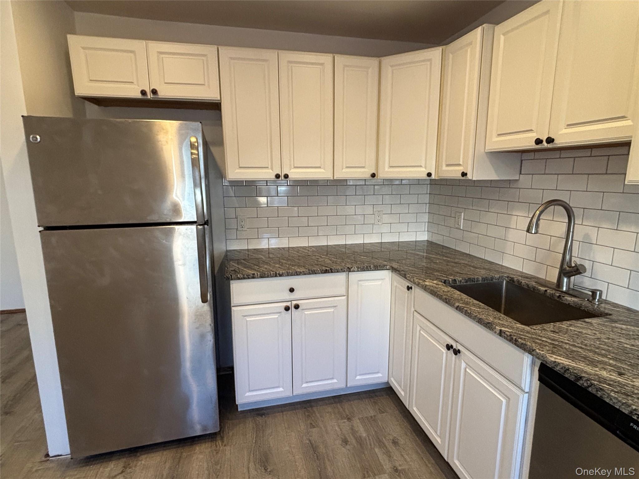 40 Canoe Place Road, Unit 4 Hampton Bays, NY 11946 - Photo 10 of 36 a kitchen with appliances a sink and cabinets